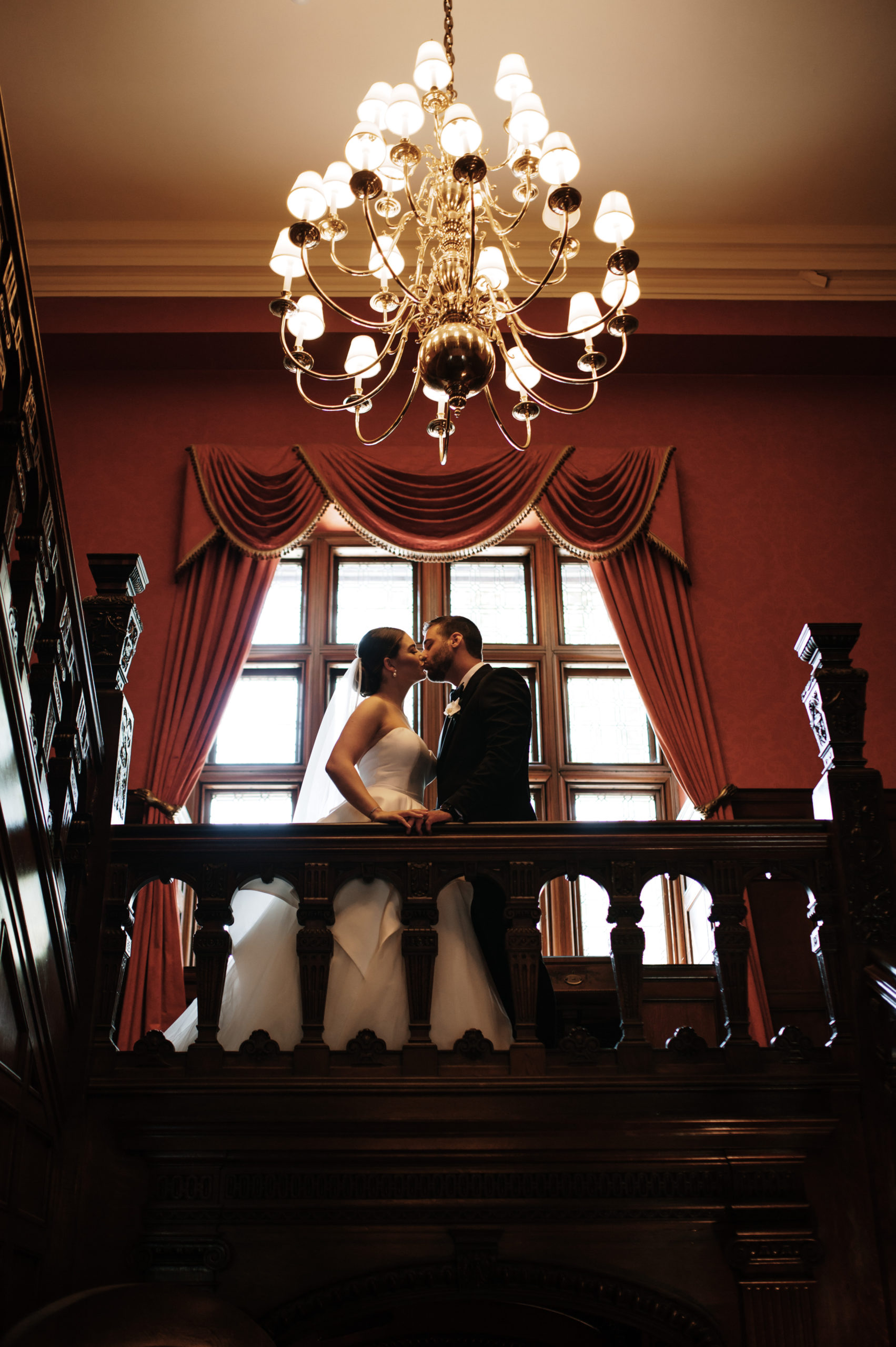Bride and groom kiss in front of a beautiful square window
