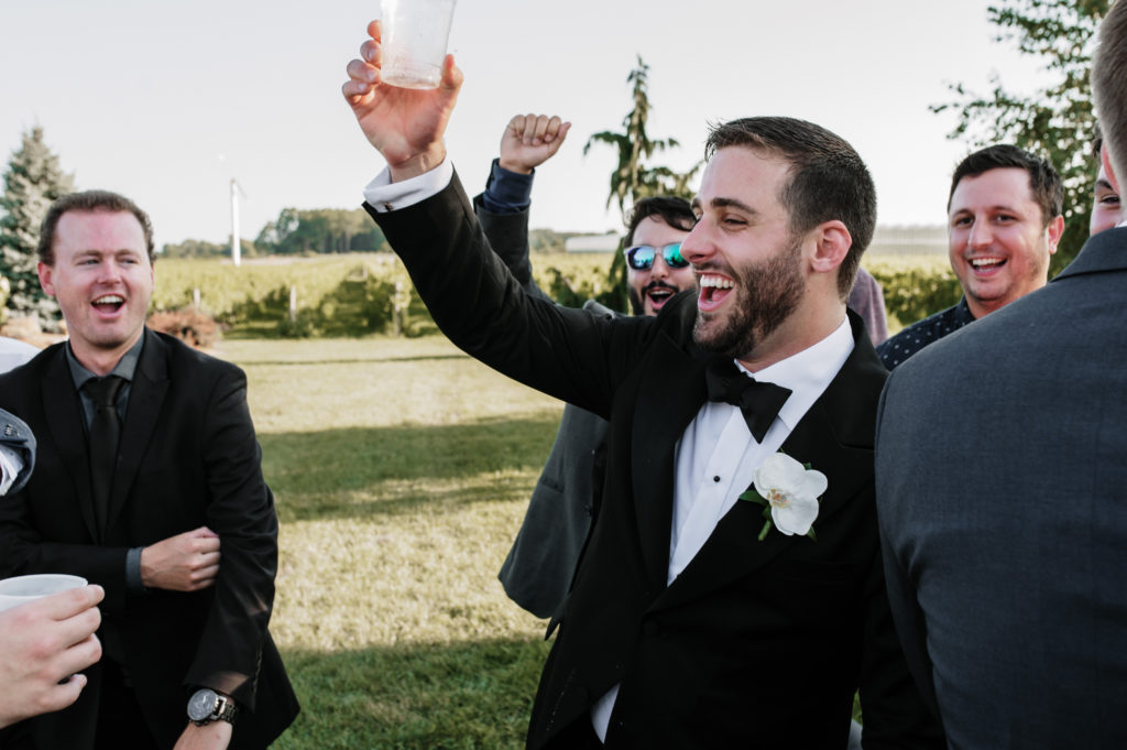 A groom drinking alcohol with his friends 